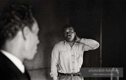 A candidate ponders what he’s hearing as voter-registration organizer Frank Robinson offers assistance,  Sumter,  South Carolina.  1962