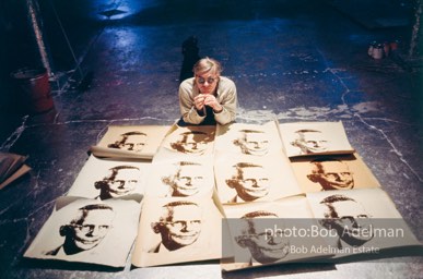Andy Warhol with prints of TheAmerican Man (Portraitof Watson Powell) (1964)on the Factory floor.
