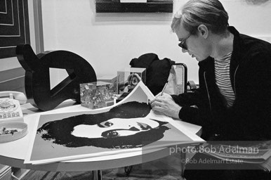 Andy Warhol signs his Liz Taylor prints at the Leo Castelli Gallery. New York City, 1965.