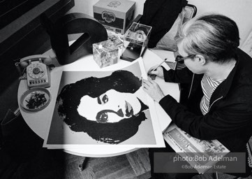 Andy Warhol signs his Liz Taylor prints at the Leo Castelli Gallery. New York City, 1965.