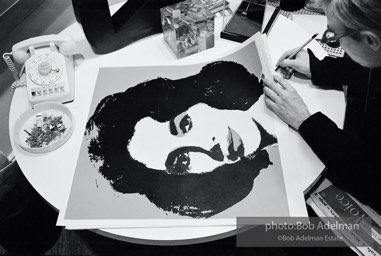 Andy Warhol signs his Liz Taylor prints at the Leo Castelli Gallery. New York City, 1965.