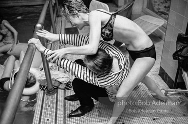Edie Sedgwick is determined to push Andy Warhol into the pool at Al Roon's Gym. New York City, 1965.