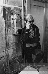 Andy Warhol at the payphone at the Factory. 1965.