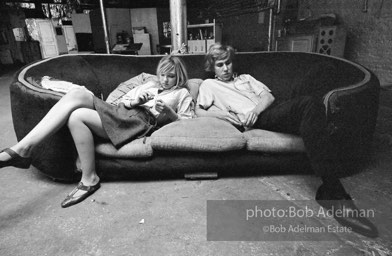 Bibbe Hanson and Chuck Wein on the infamous red couch at Warhol's Factory. New York City, 1965.