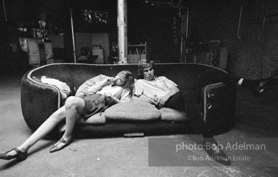 Bibbe Hanson and Chuck Wein on the infamous red couch at Warhol's Factory. New York City, 1965.