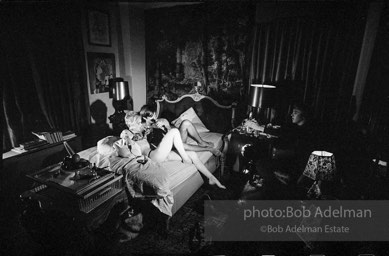 During Beauty #2, Edie Sedgwick answers questions from Chuck Wein off-camera in the shadows  while grappling with Gino Piserchio on the bed. New York City apartment, 1965.