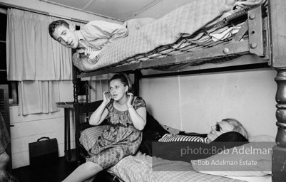 Andy Warhol with unidentified guests horsing around on the bunk beds at a dinner party. New York City, 1965.