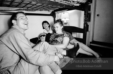 Andy Warhol with unidentified guests horsing around on the bunk beds at a dinner party. New York City, 1965.