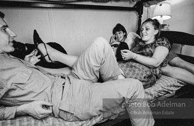 Andy Warhol with unidentified guests horsing around on the bunk beds at a dinner party. New York City, 1965.