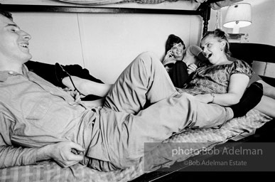 Andy Warhol with unidentified guests horsing around on the bunk beds at a dinner party. New York City, 1965.