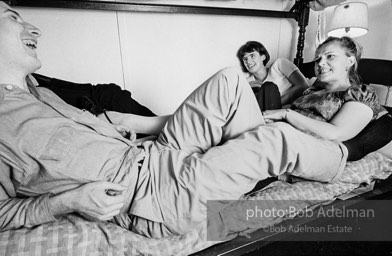 Andy Warhol with unidentified guests horsing around on the bunk beds at a dinner party. New York City, 1965.