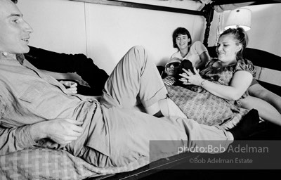 Andy Warhol with unidentified guests horsing around on the bunk beds at a dinner party. New York City, 1965.