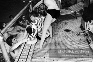 Edie Sedgwick is determined to push Andy Warhol into the pool at Al Roon's Gym. New York City, 1965.