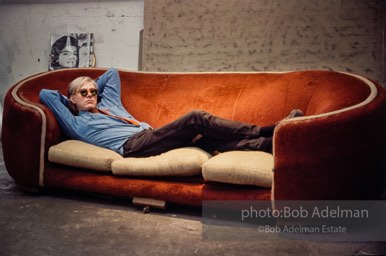 Andy Warhol on the red couch at the Factory. New York City, 1964.
