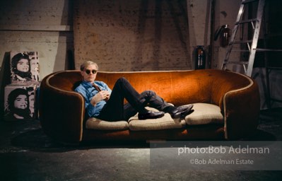 Andy Warhol on the red couch at the Factory. New York City, 1964.