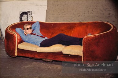 Andy Warhol on the red couch at the Factory. New York City, 1964.