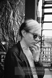 Andy Warhol on the Factory fire escape ouside of the Factory overlooking East 47th St. New York City, 1965.