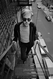 Andy Warhol on the Factory fire escape ouside of the Factory overlooking East 47th St. New York City, 1965.