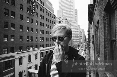 Andy Warhol on the Factory fire escape ouside of the Factory overlooking East 47th St. New York City, 1965.