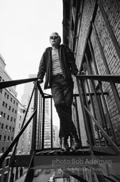 Andy Warhol on the Factory fire escape ouside of the Factory overlooking East 47th St. New York City, 1965.