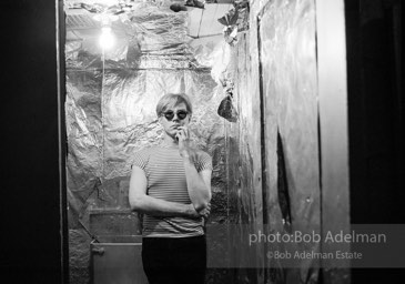 Andy Warhol in the silver foil covered bathroom at the Factory, 1965.