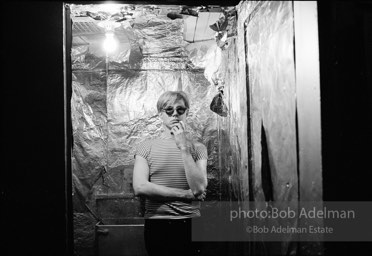 Andy Warhol in the silver foil covered bathroom at the Factory, 1965.