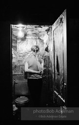 Andy Warhol in the silver foil covered bathroom at the Factory, 1965.