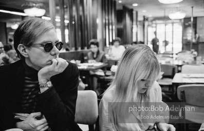 Andy Warhol and Bibbe Hanson at a mid-town restaurant, New York City, 1965.