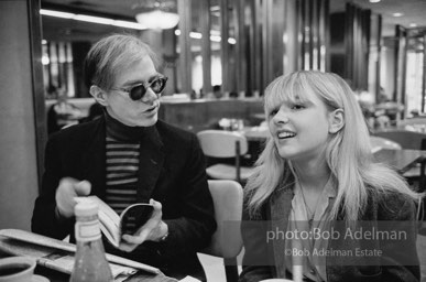 Andy Warhol and Bibbe Hanson at a mid-town restaurant, New York City, 1965.