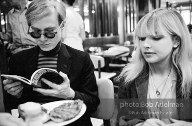 Andy Warhol and Bibbe Hanson at a mid-town restaurant, New York City, 1965.