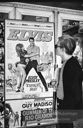 Warhol looks at a movie theater billboard in th Times Square area. New York City, 1965.