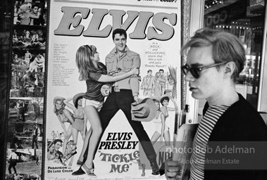 Warhol looks at a movie theater billboard in th Times Square area. New York City, 1965.