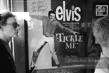 Warhol looks at a movie theater billboard in th Times Square area. New York City, 1965.