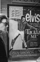 Warhol looks at a movie theater billboard in th Times Square area. New York City, 1965.